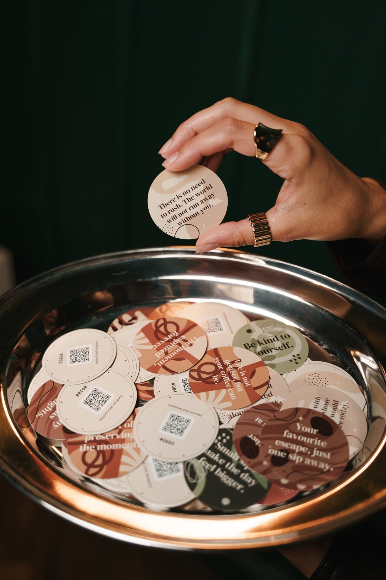 Hand placing a round message card on a tray of cards.