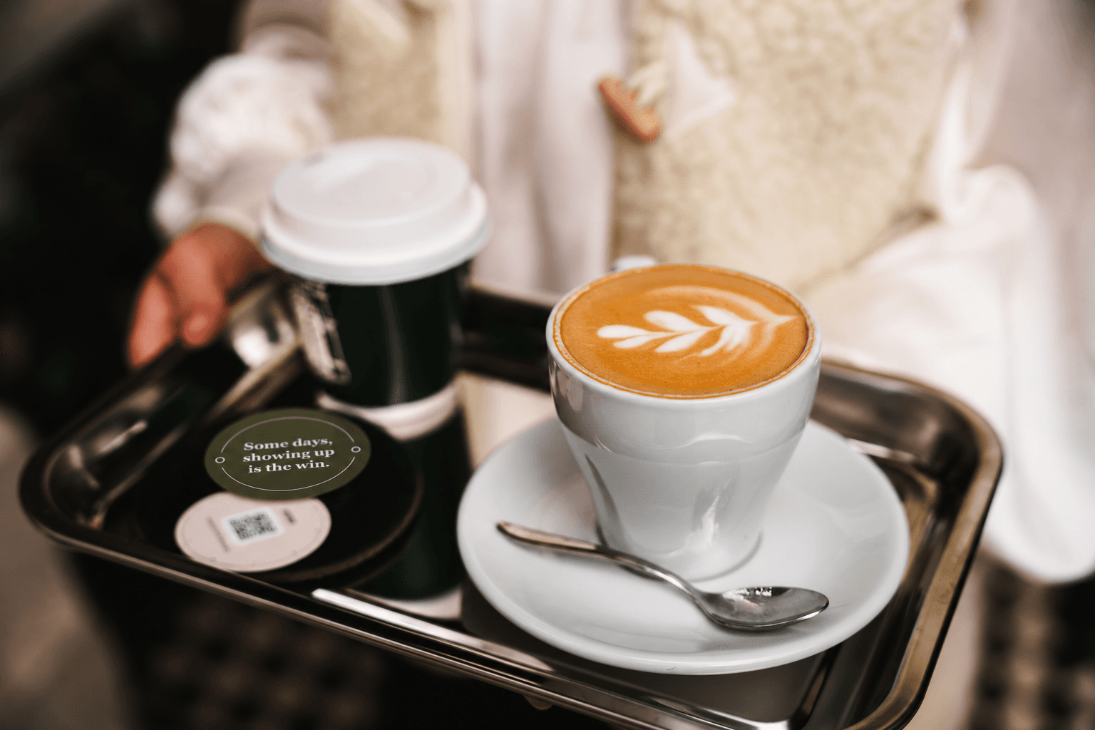 Coffee on a tray beside the green message side and pink QR side of LuckySip cards