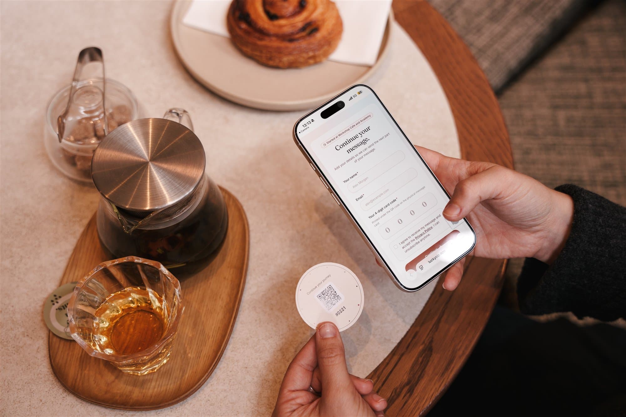 Phone showing a LuckySip page beside coffee and a QR card.